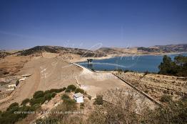 Image du Maroc Professionnelle de  Le barrage Oued El Makhazine, conçu pour le développement et  l'irrigation du périmètre du Loukkos. Ainsi les champs situés dans le triangle Ksar El Kébir, Larache, Moulay Bouselham profitent de cette infrastructure. Cette importante réalisation située sur El Oued Loukkos sert à la régularisation inter annuelle des débits tout en formant une protection contre les crues, au Jeudi 1er Septembre 2005 à cette datte le barrage dispose 309 Million de M3. (Photo / Abdeljalil Bounhar) 